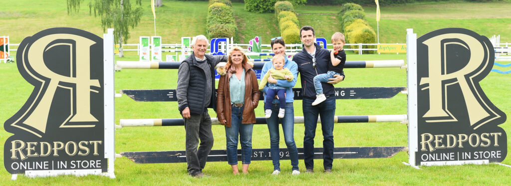 The Tuff Family at Bicton Arena in front of the Redpost Equestrian Show Jumping wings